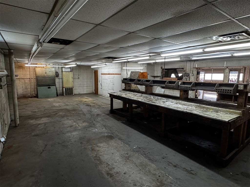 A large empty room with a long table in the middle of it.
