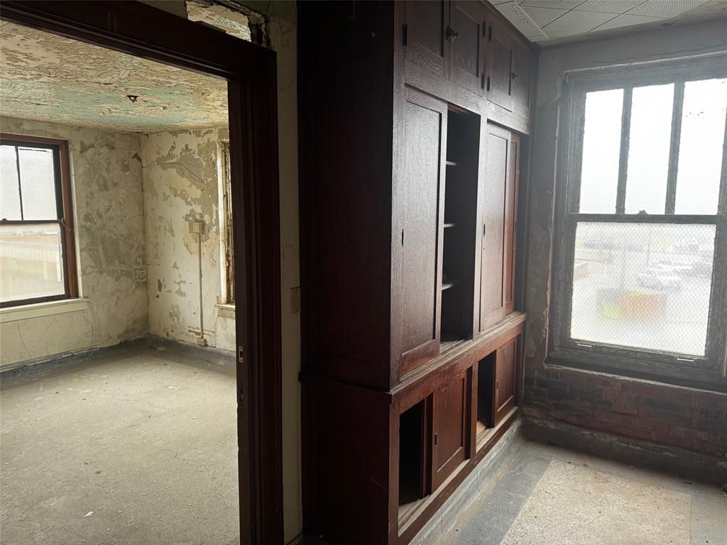 A room with a lot of windows and wooden cabinets
