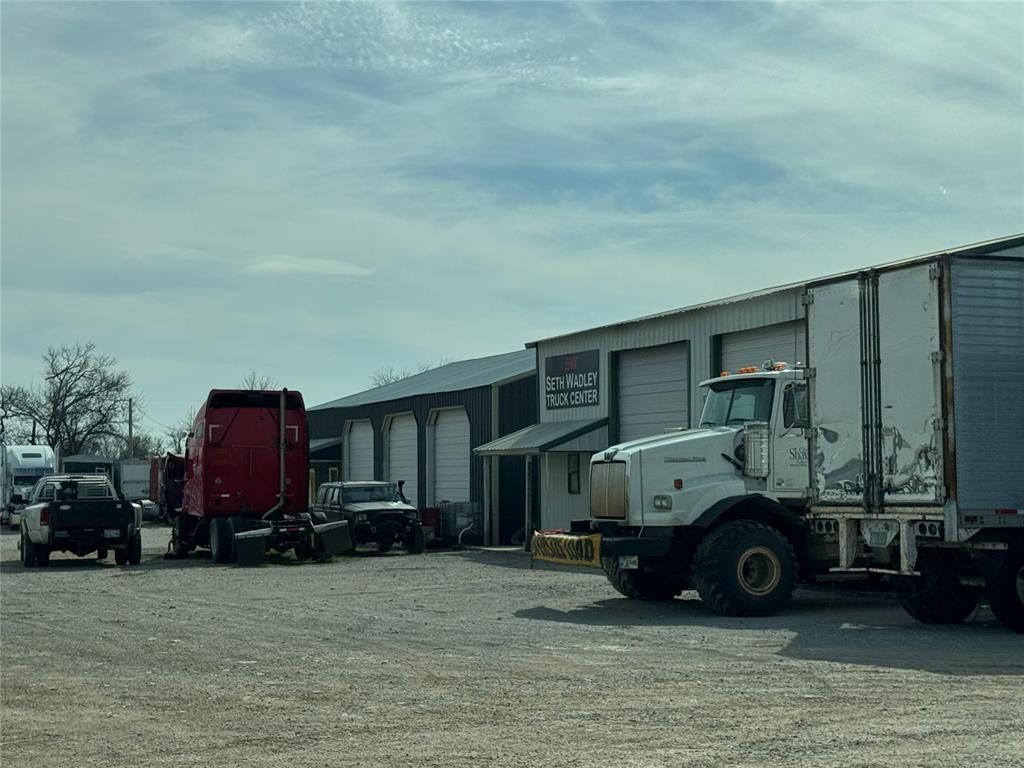 A truck is parked in front of a building in a parking lot.