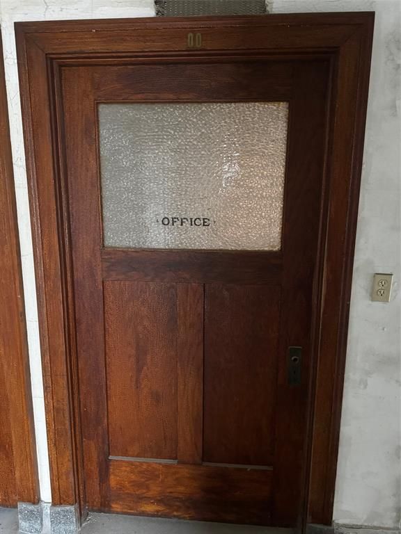 A wooden door with a glass window and the word office written on it.