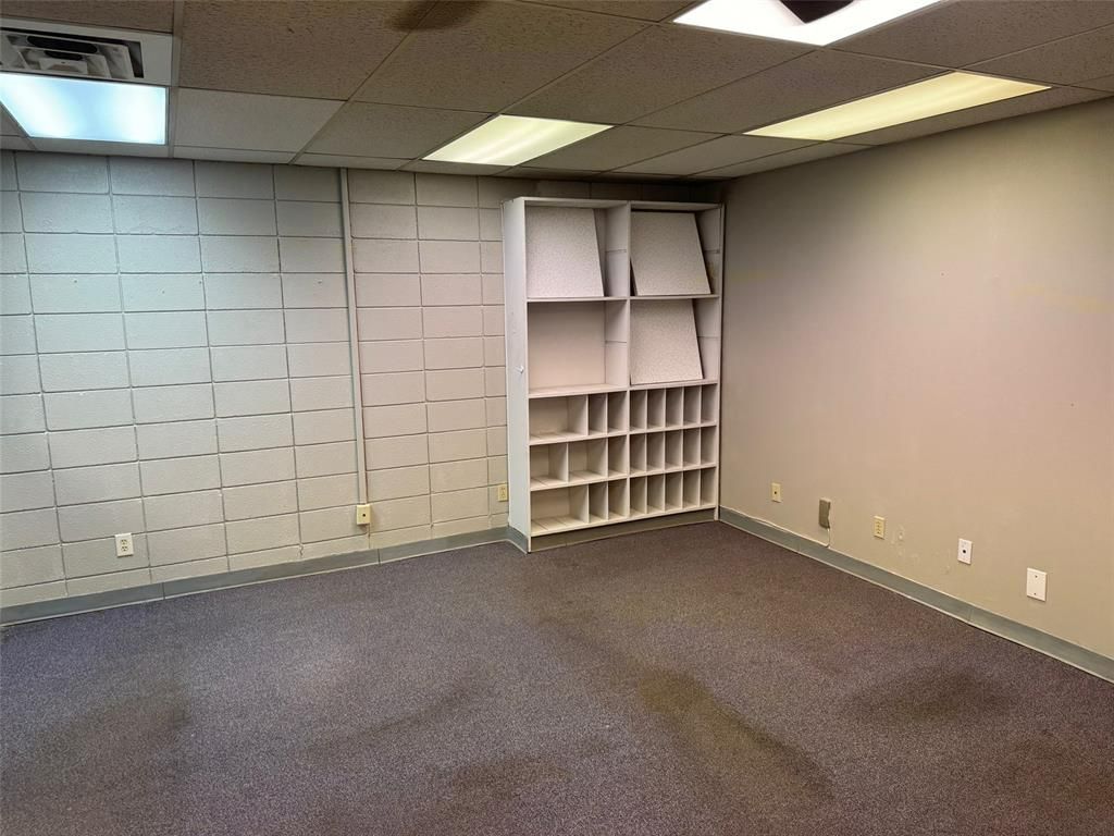 An empty room with a shelf in the middle of it