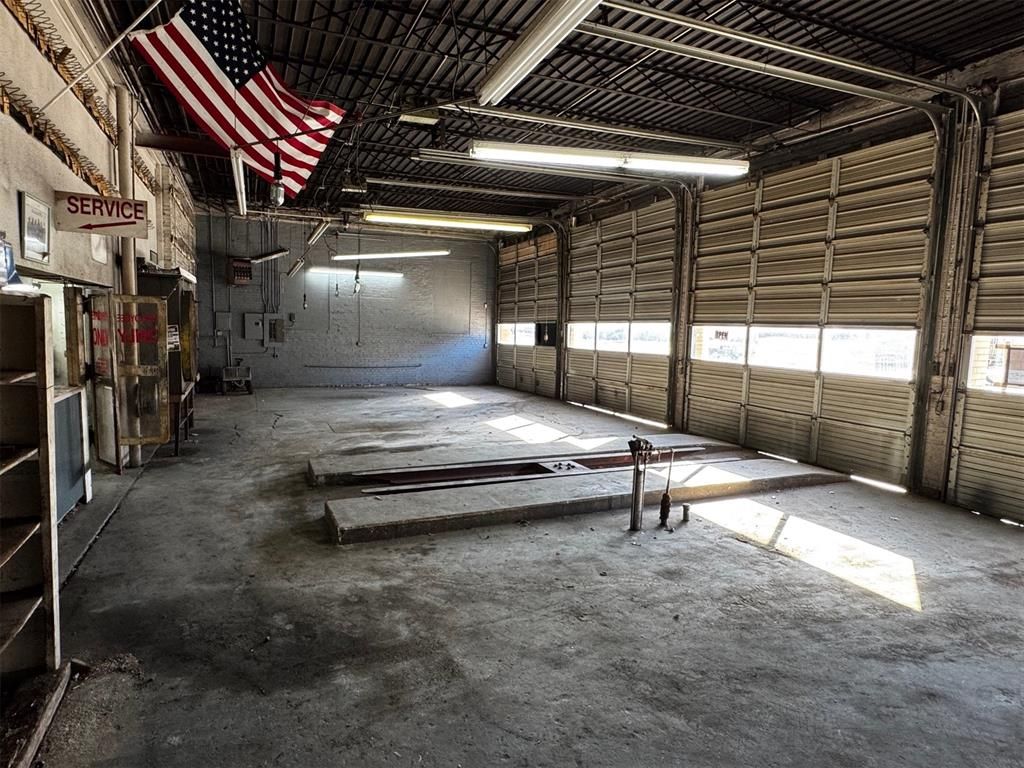 An empty garage with an american flag hanging from the ceiling.