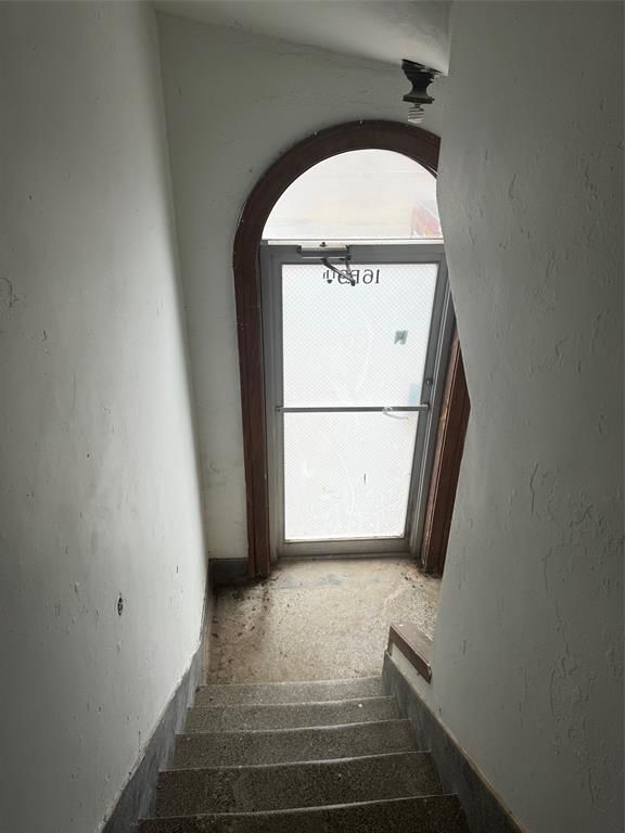 A staircase leading up to a door with a glass door