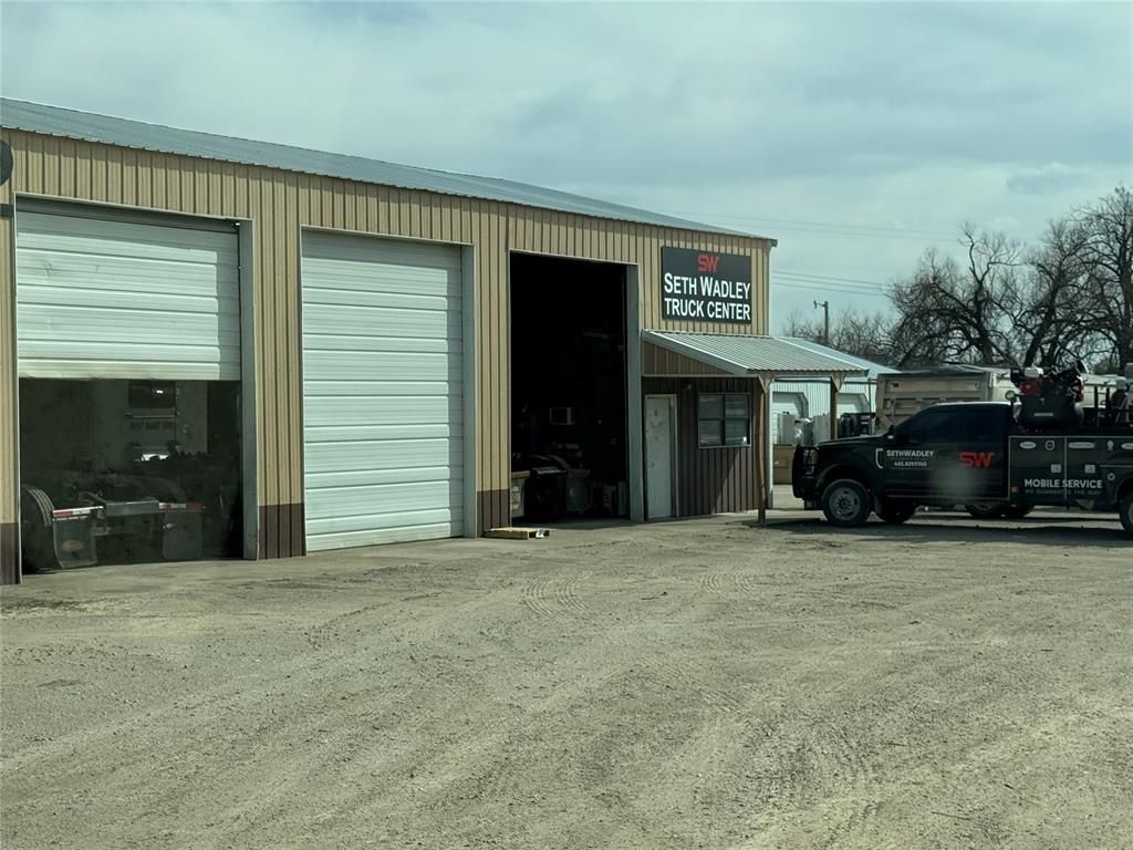 A truck is parked in front of a garage.