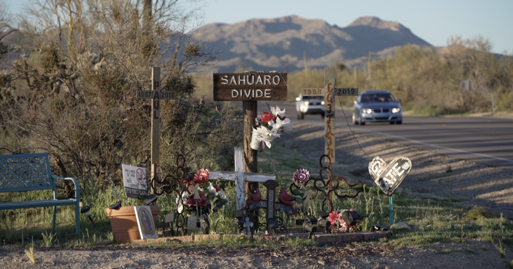 A sign on the side of a road says sahuaro divide.