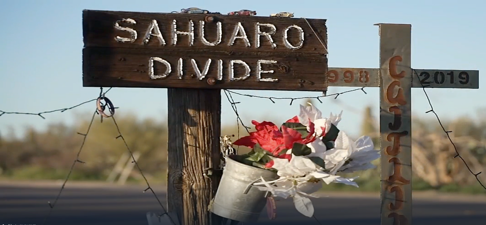 A wooden sign that says ' sahuaro divide ' on it