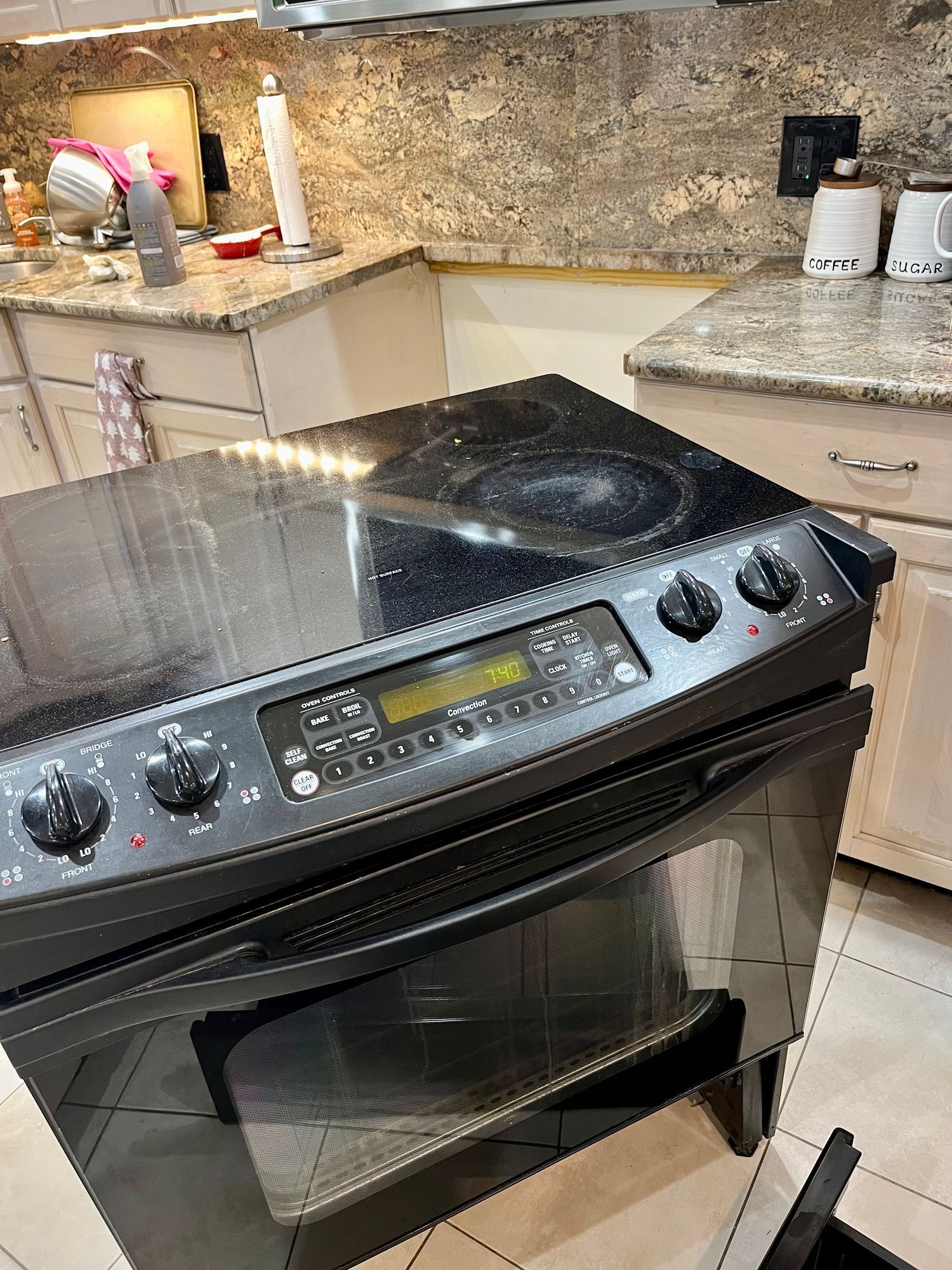 A black stove top oven is sitting in a kitchen with the door open.