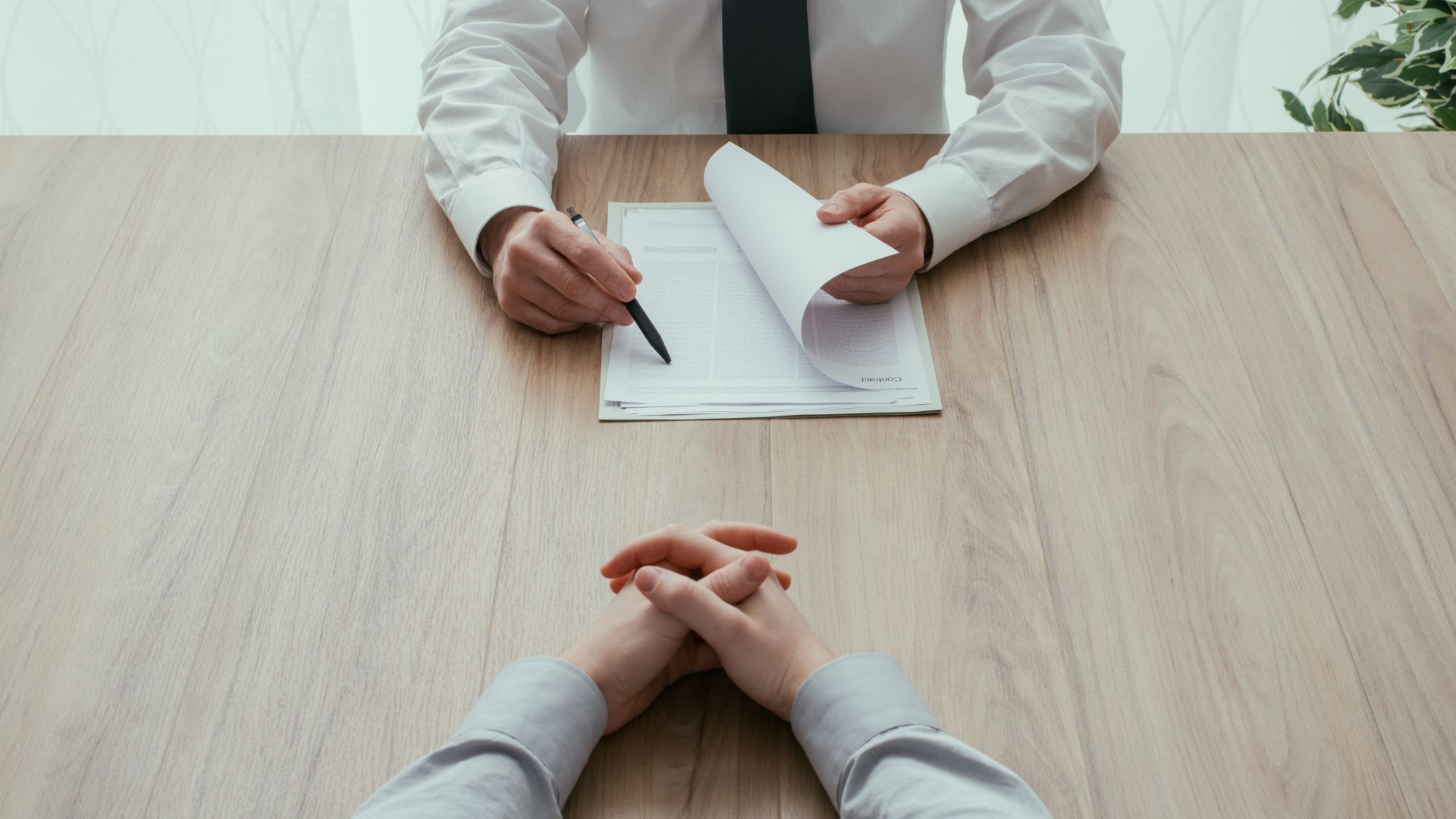 A man and a woman are sitting at a table having a job interview.