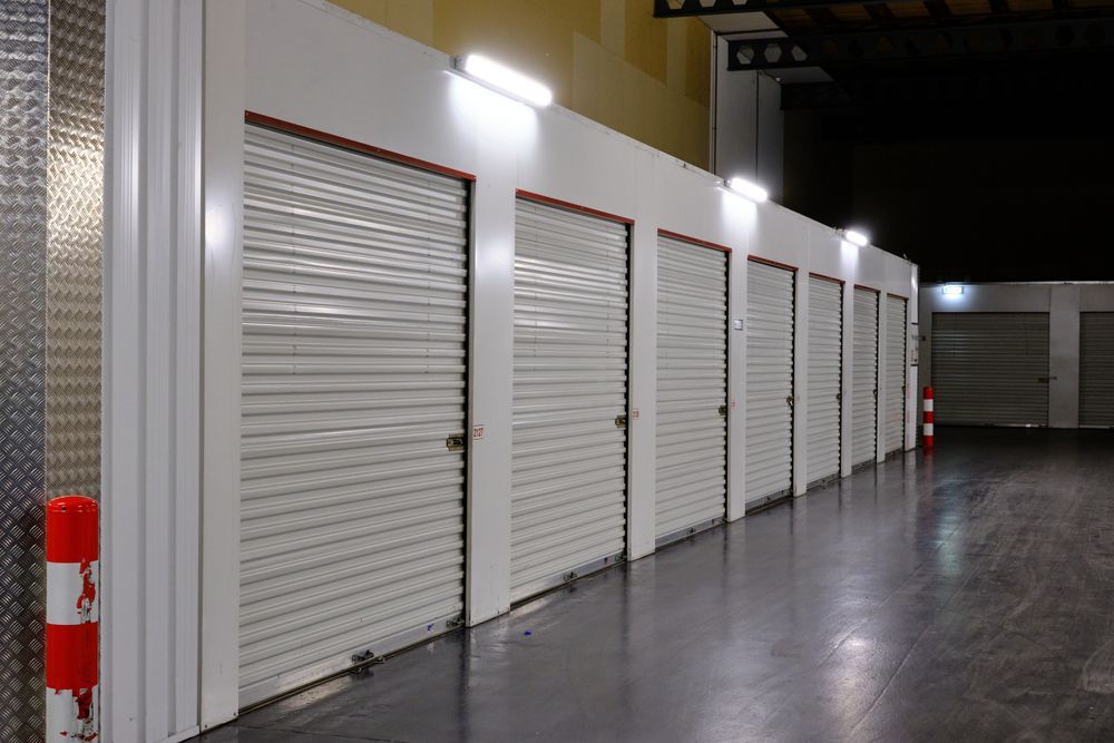 A row of empty storage units in a warehouse at night.