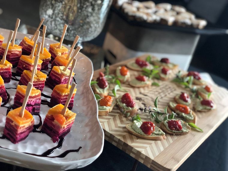 Colorful appetizer skewers and a charcuterie-style platter with strawberries on wooden serving boards