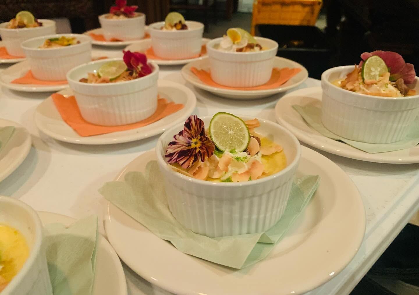 Dishes of colorful dessert cups arranged on white plates at a buffet table