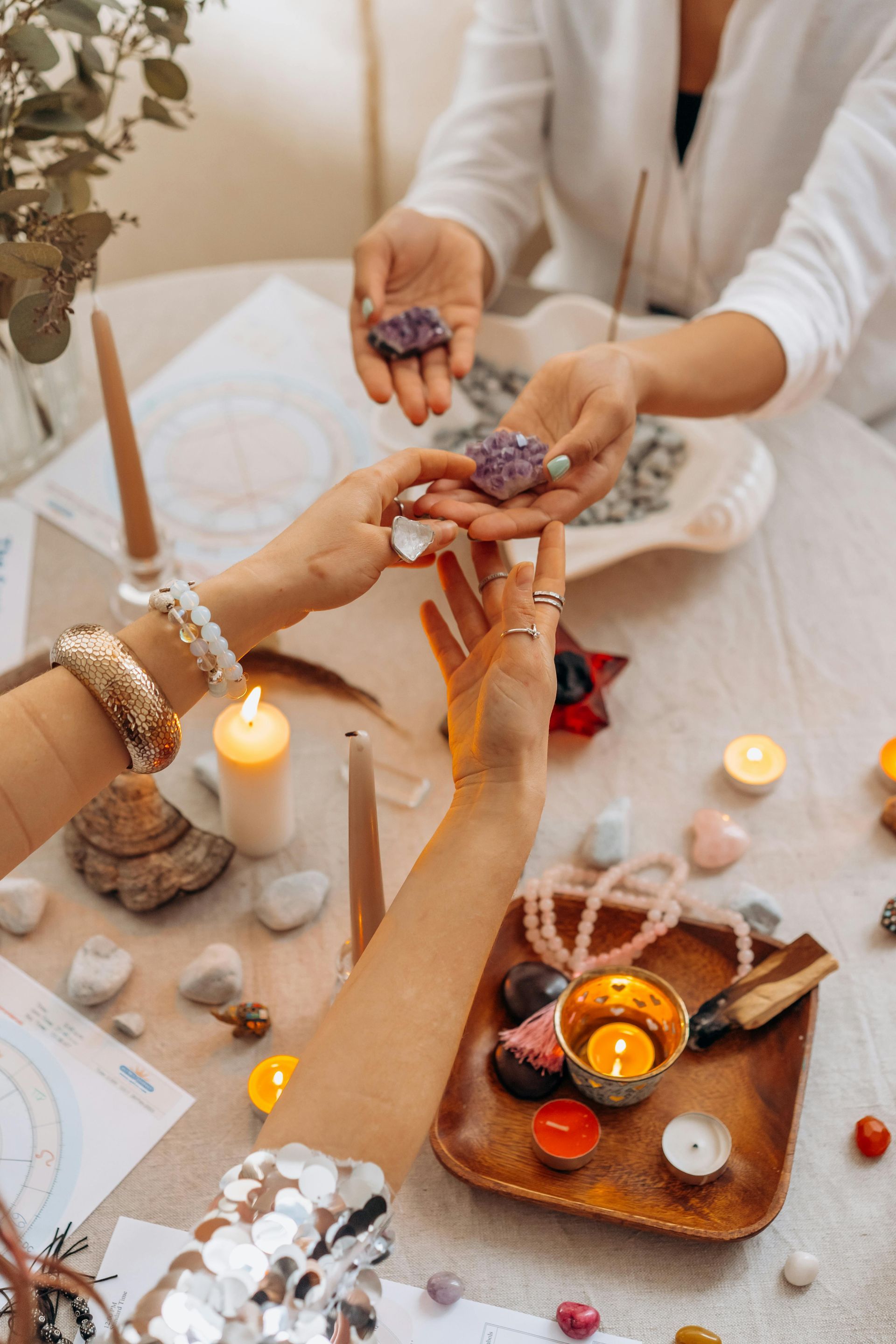 A group of people are sitting at a table holding crystals in their hands.