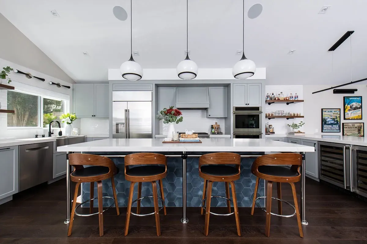 A kitchen with a large island and stools.