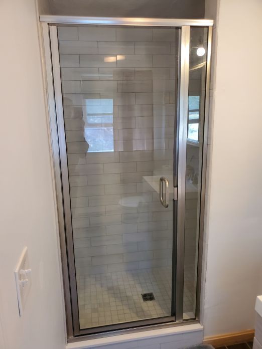 A bathroom with a sliding glass shower door