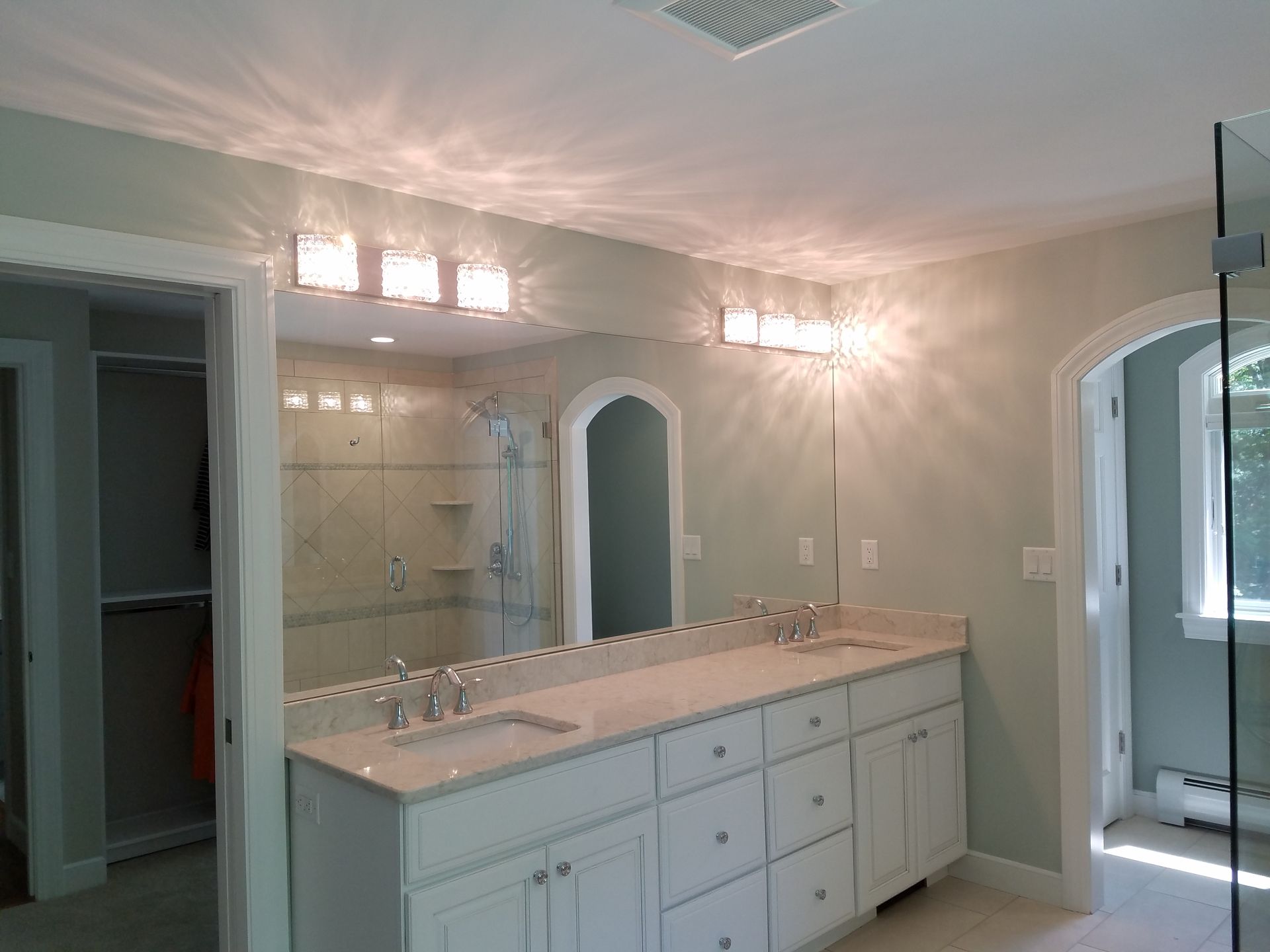 A bathroom with two sinks and a large mirror.