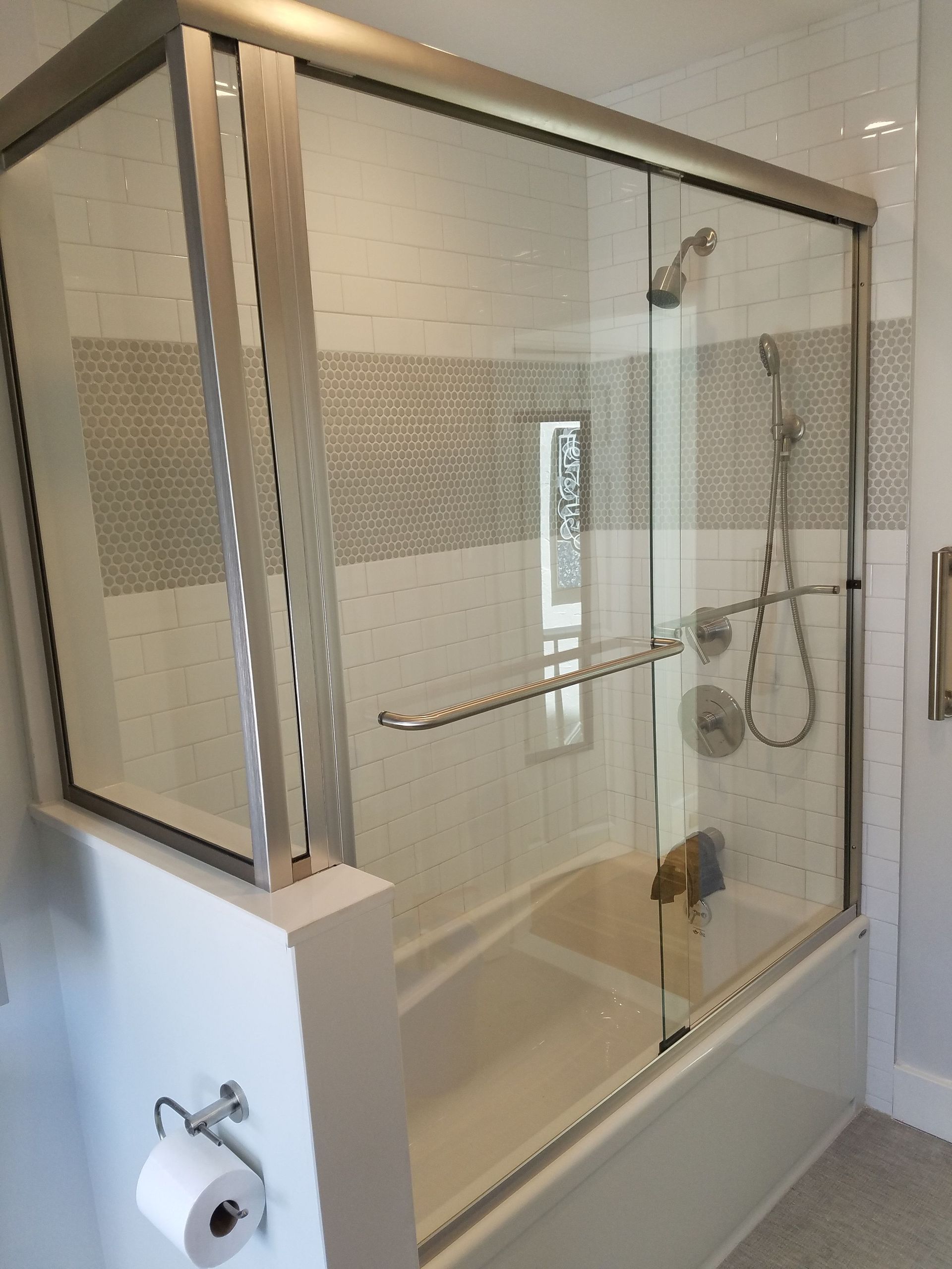 A bathroom with a bathtub and a shower with a glass door