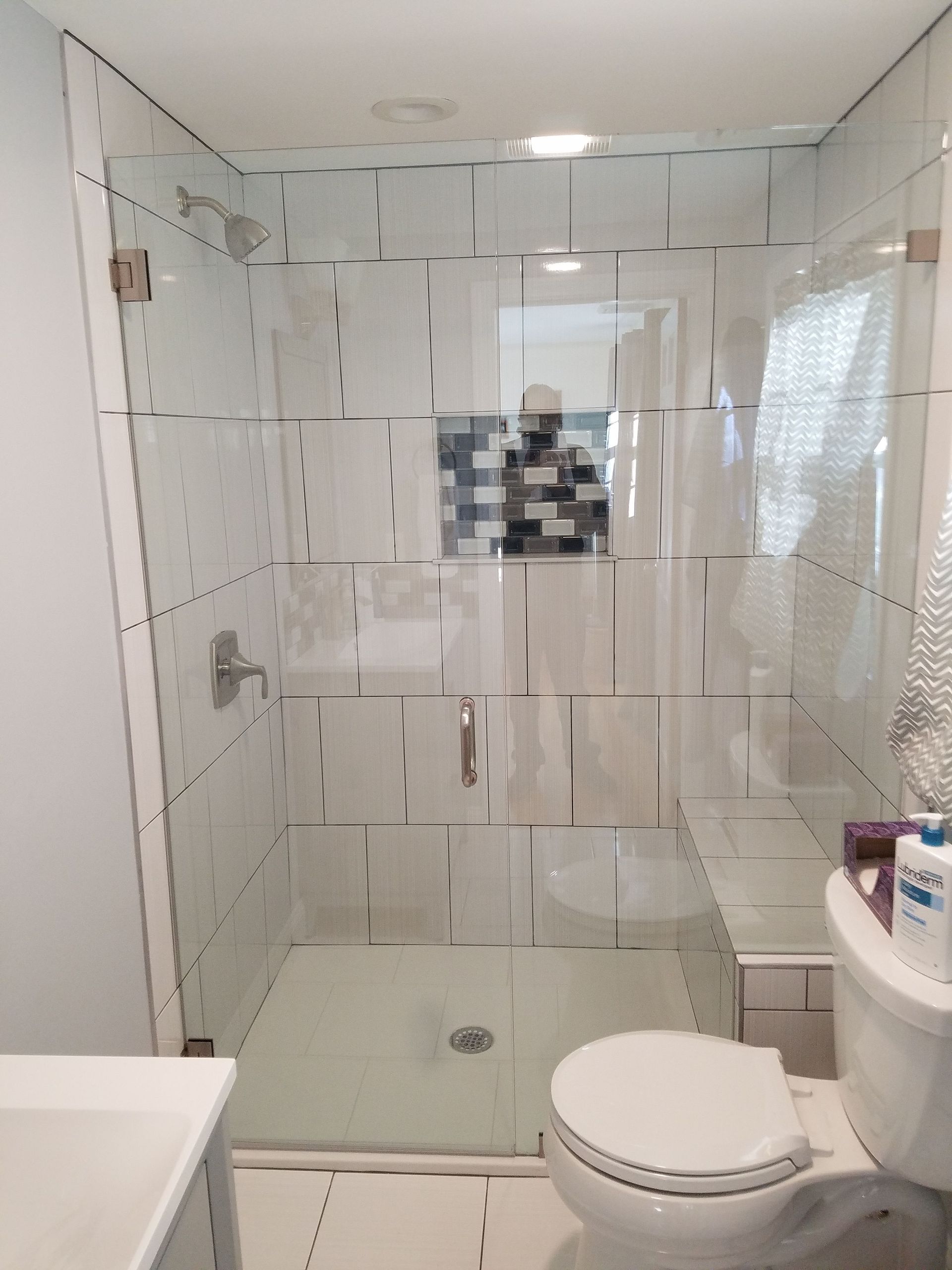 A bathroom with a toilet and a walk in shower