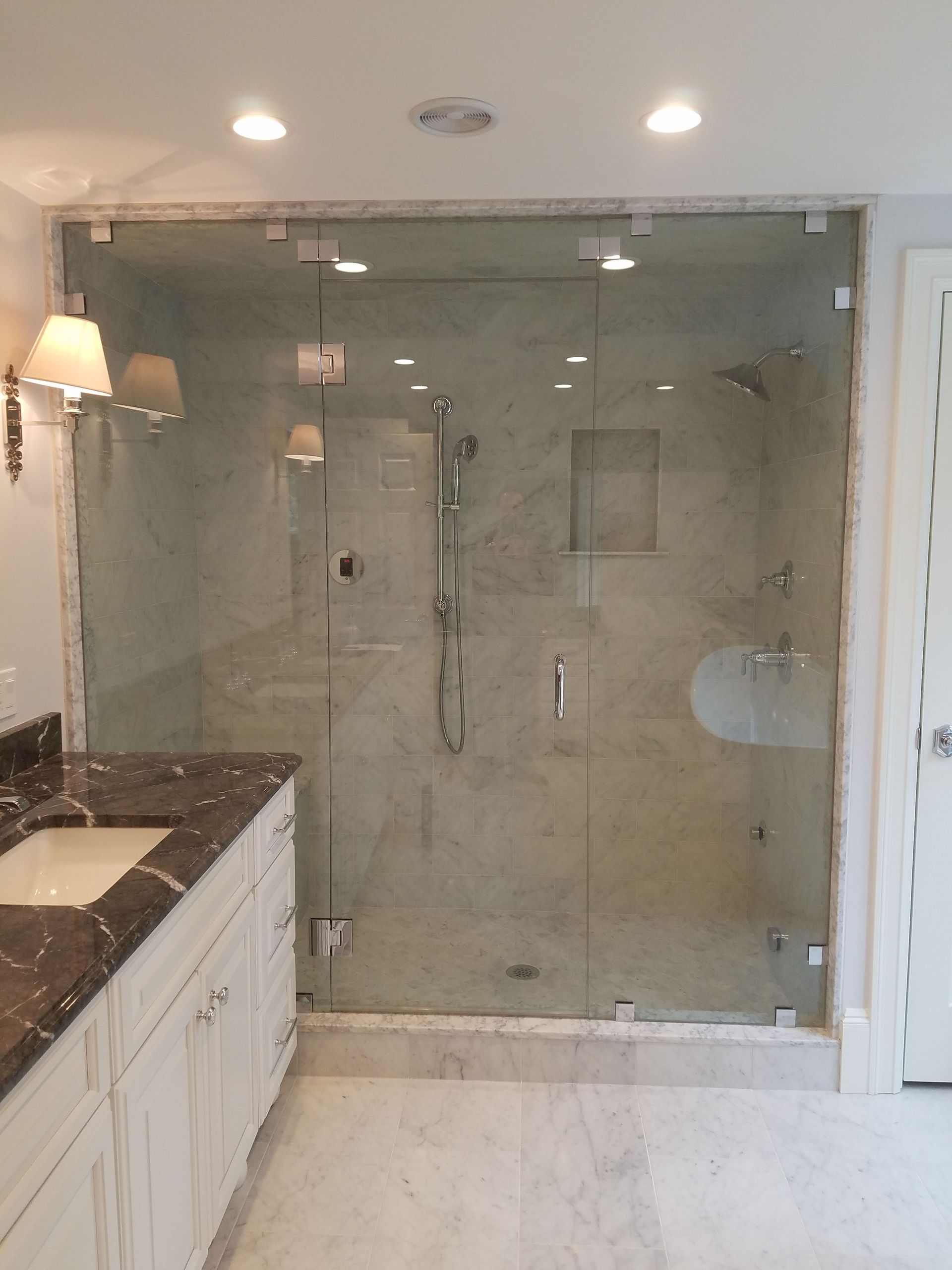 A bathroom with a walk in shower and a sink.