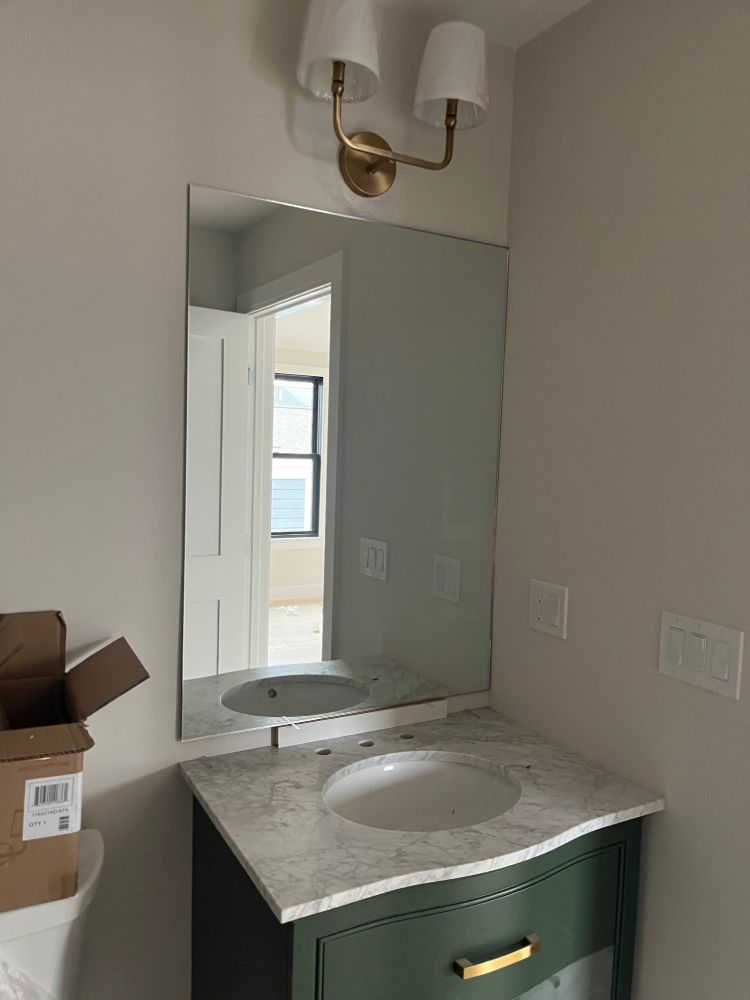 A bathroom with a sink , mirror and toilet.