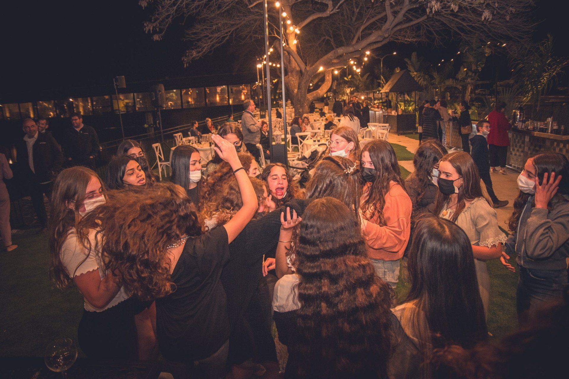 חברות שמחות עם ידיים באויר ברחבת ריקודים קטנה