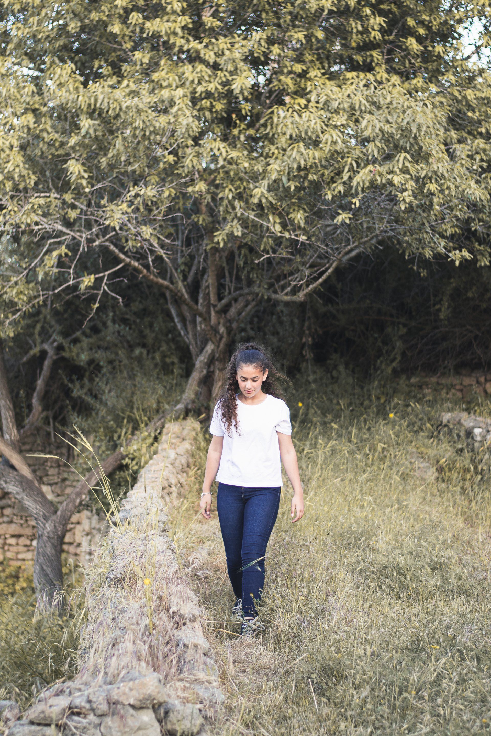 ילדת בת מצווה מביטה למצלמה בצילומים בחורשה