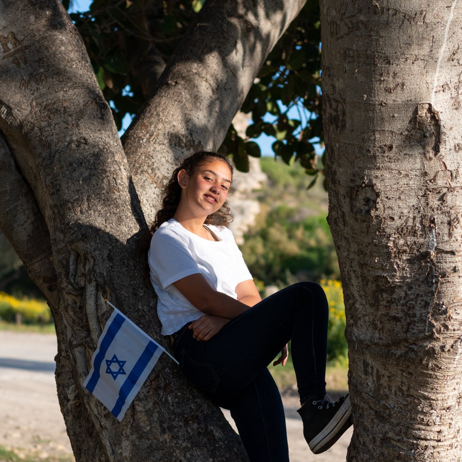 ילדת בת מצווה מחייכת למצלמה בצילומים בטבע