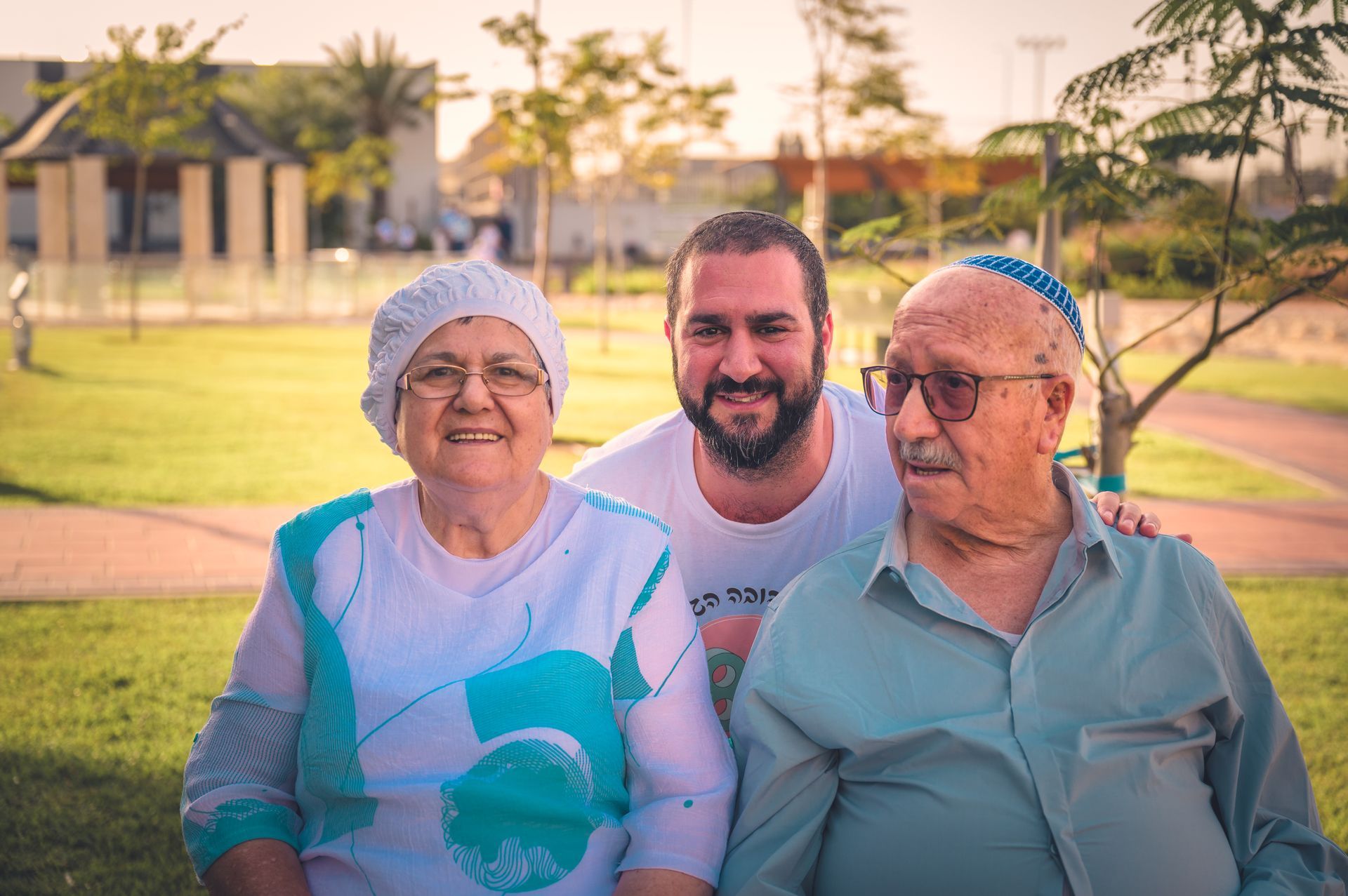 בן יושב בין אביו ואמו בצילום משפחתי