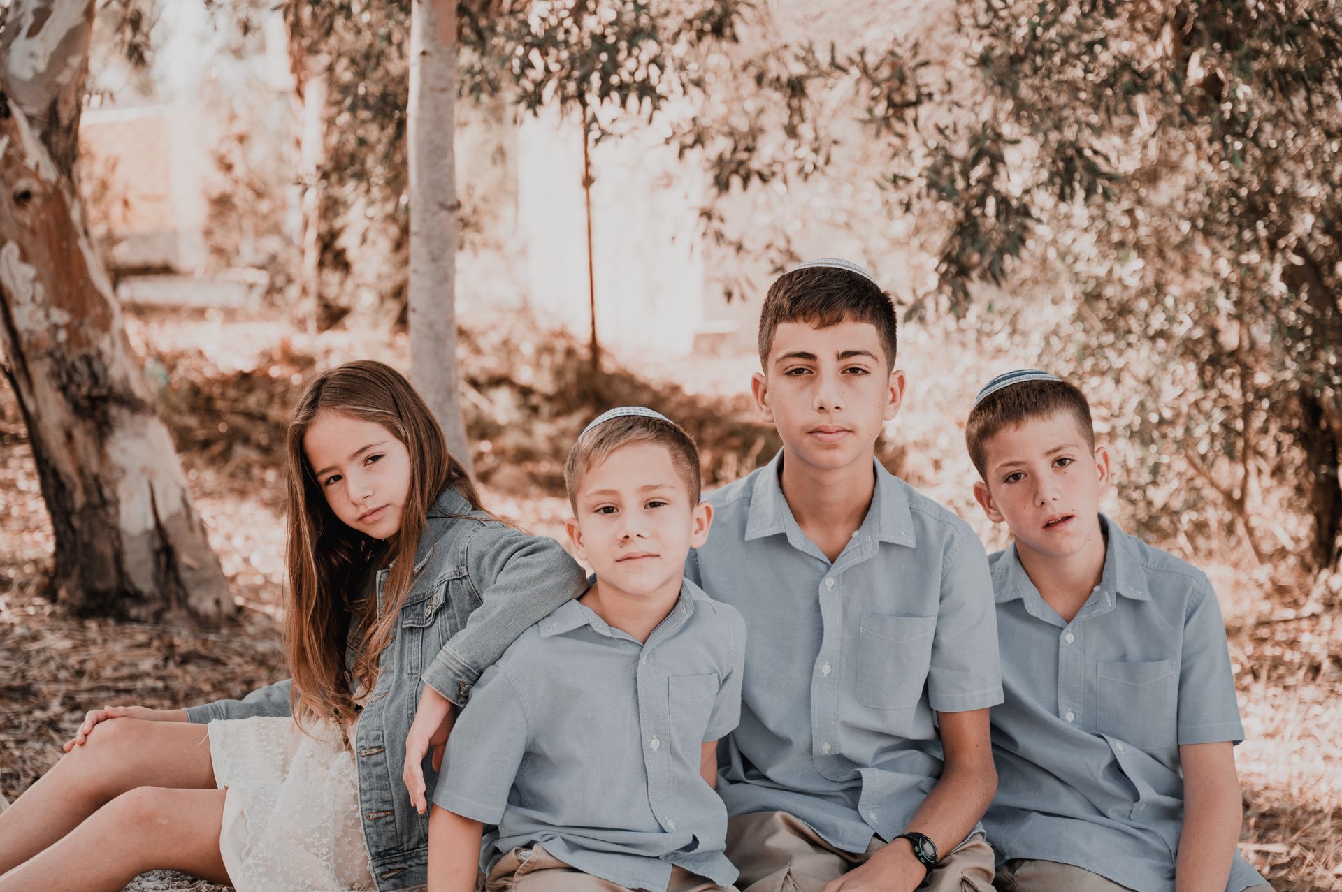 ילדים מביטים למצלמה בצילום משפחתי בטבע
