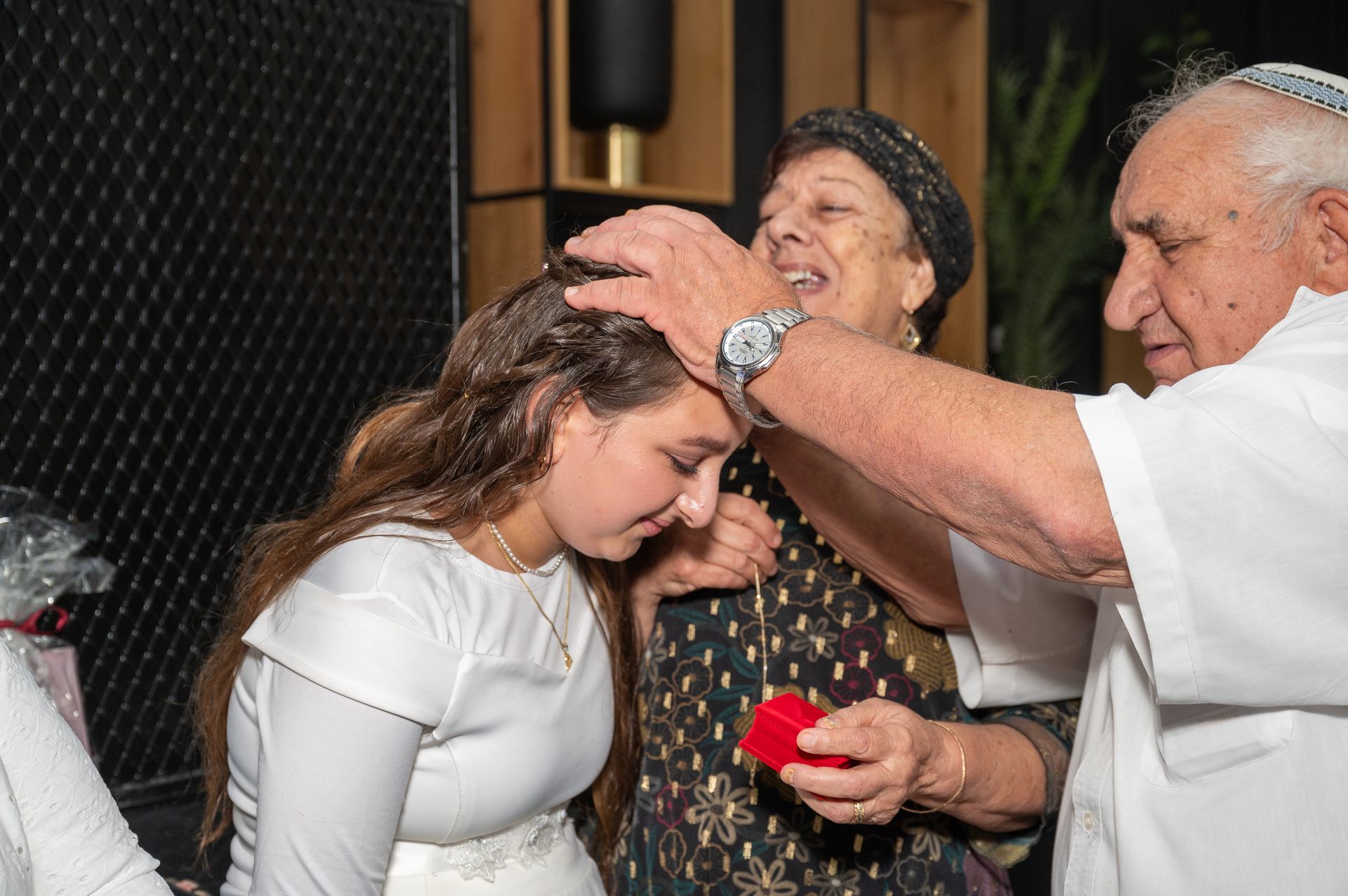 ידיים של הסבא מונחות על ראשה של בת המצווה לברכה