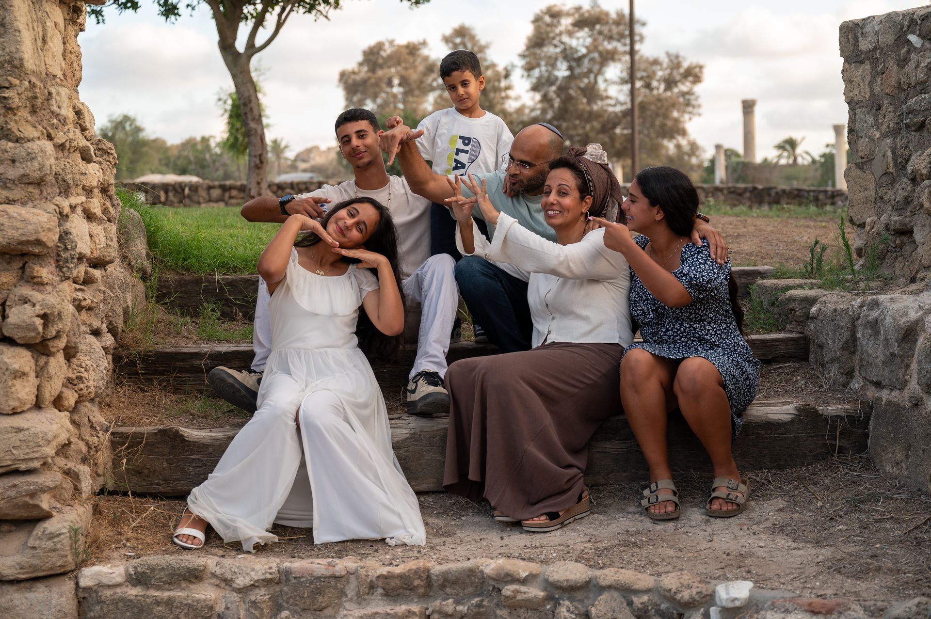 משפחה מצביעה על ילדת בת המצווה בצילומי בת מצווה בטבע