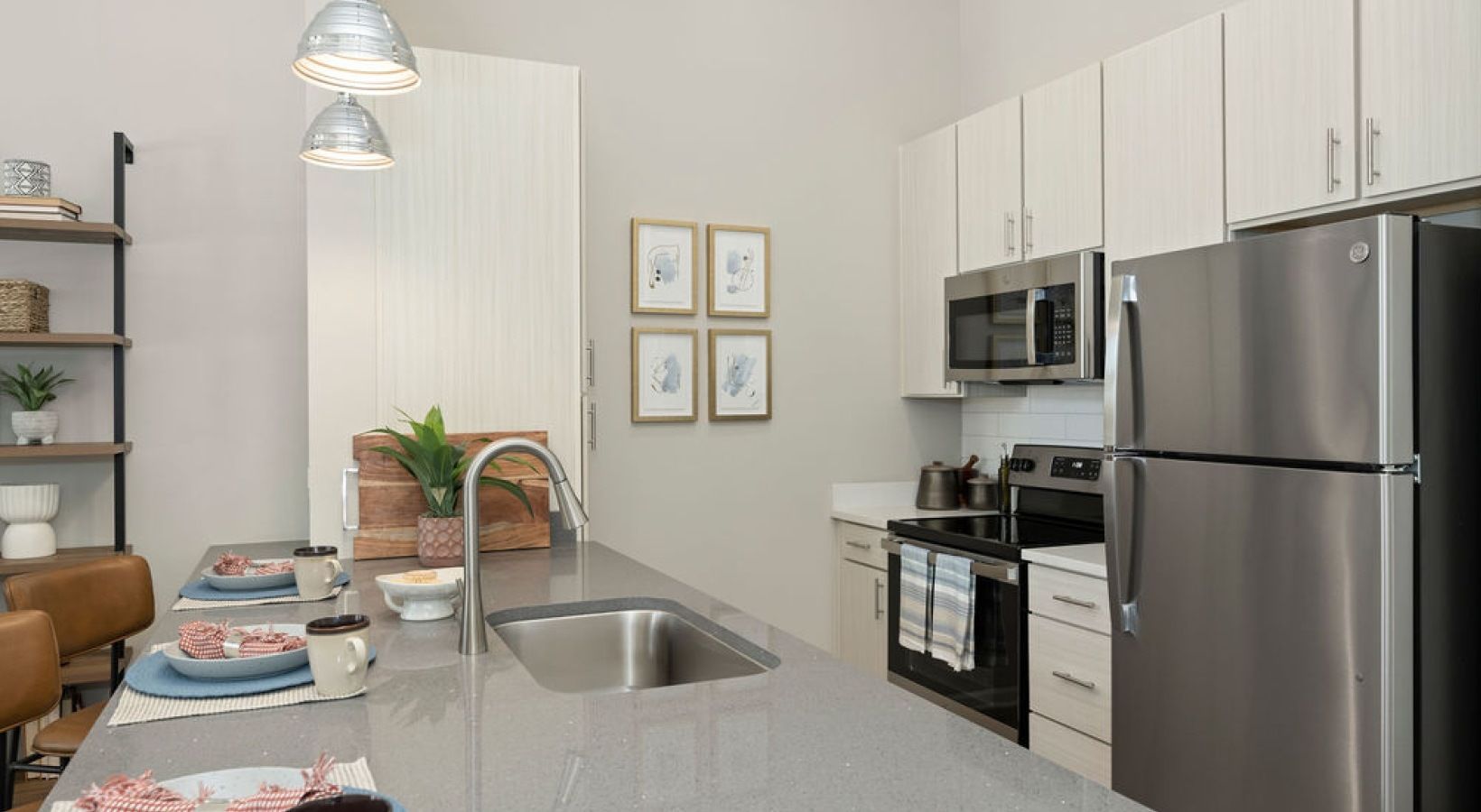 Modern apartment kitchen with an island and stainless-steel appliances.