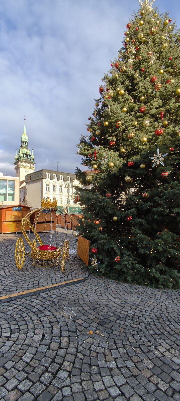 Christmas tree on the Vegetable Market in Brno with the Old Town Hall tower behind it