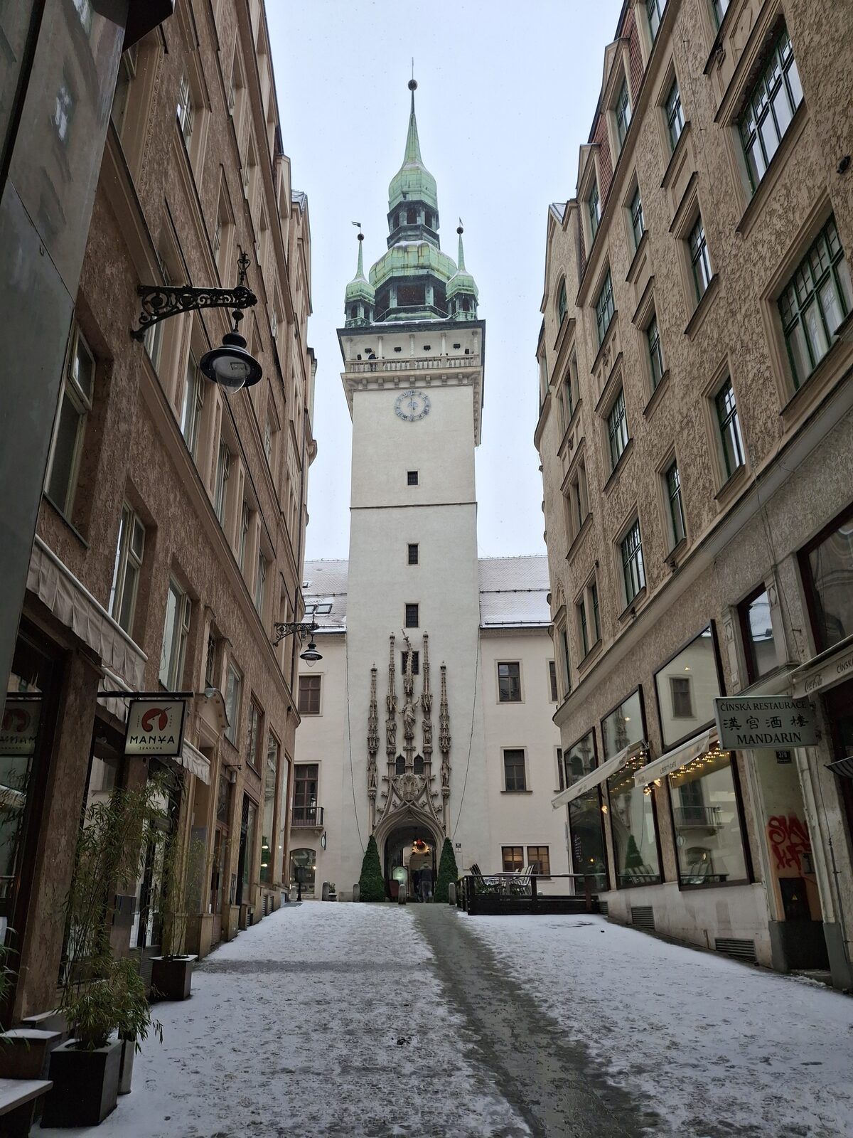 Snowy street in Brno's old town leading to the Old Town Hall tower