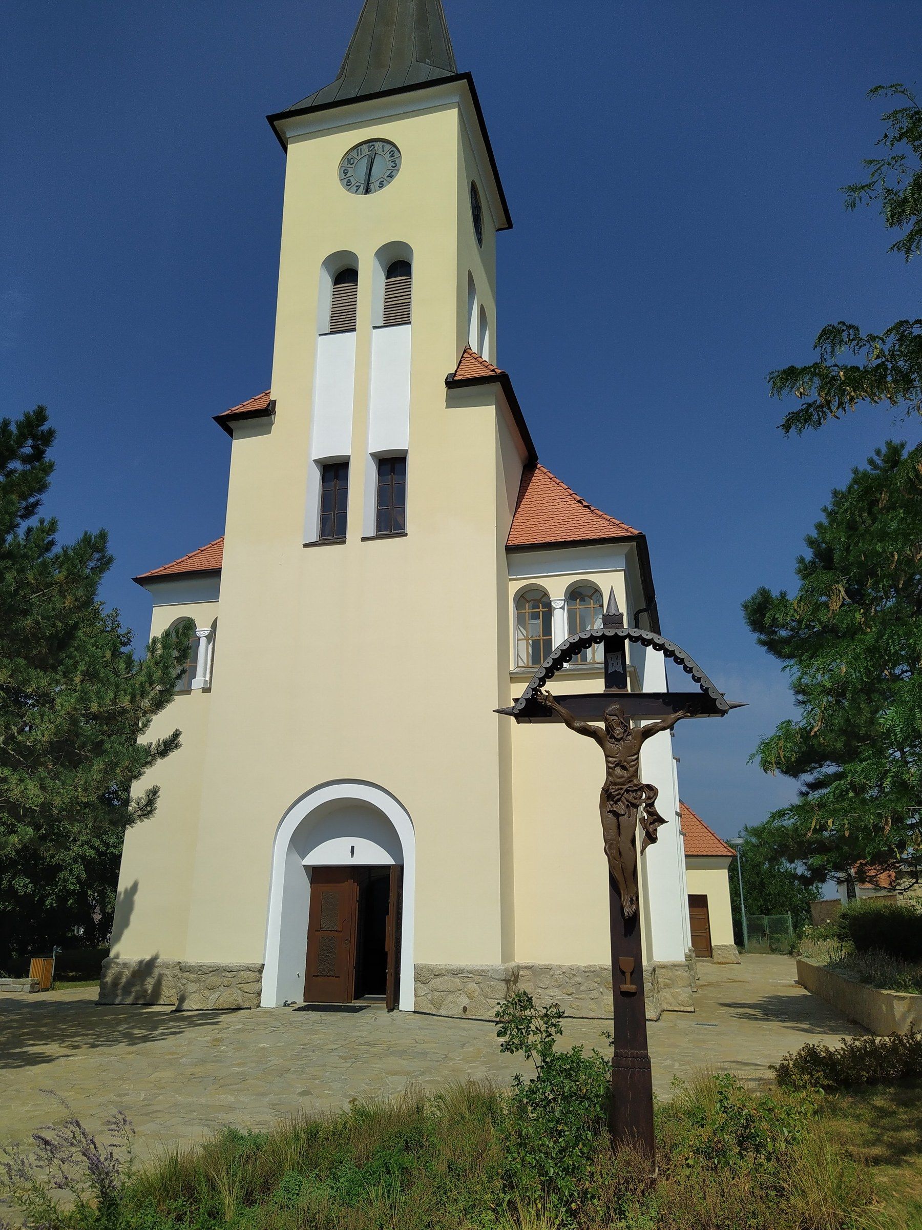 Village church with a stone cross in South Moravia