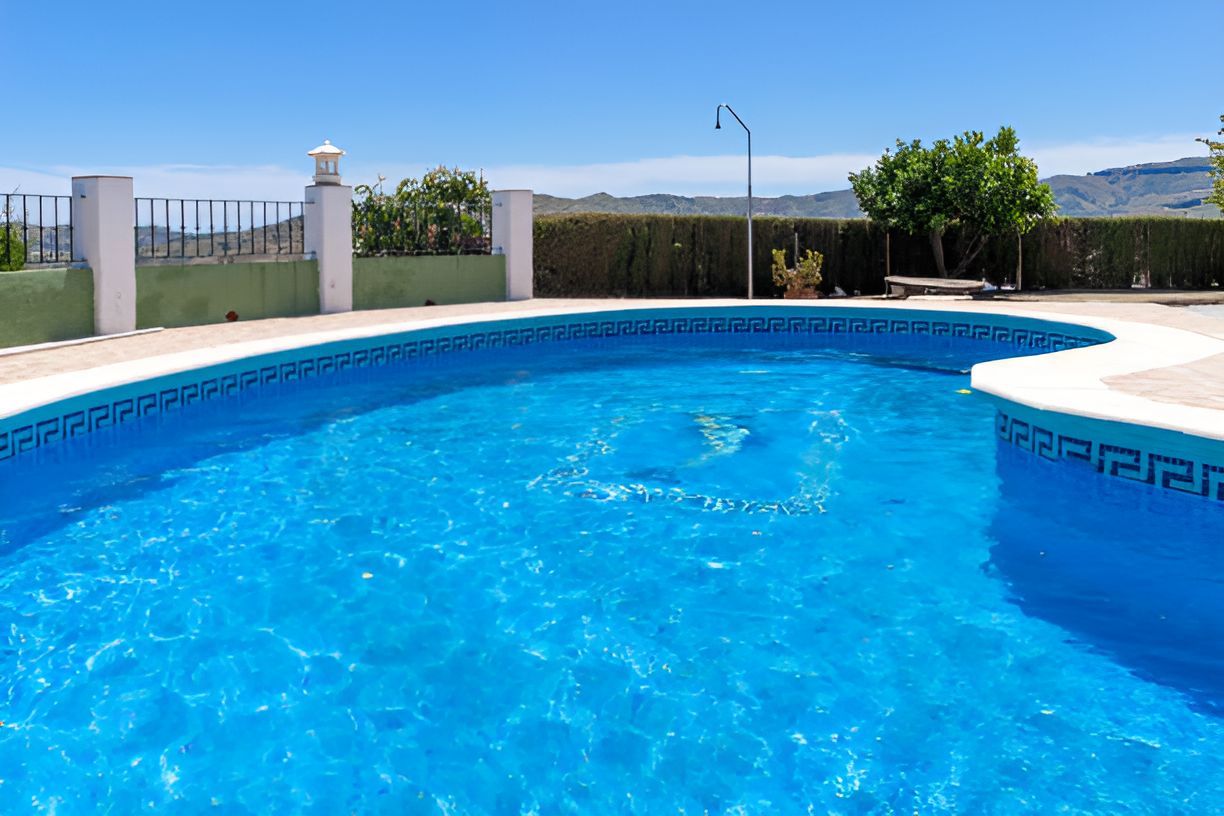 A large swimming pool with a view of the mountains in the background.