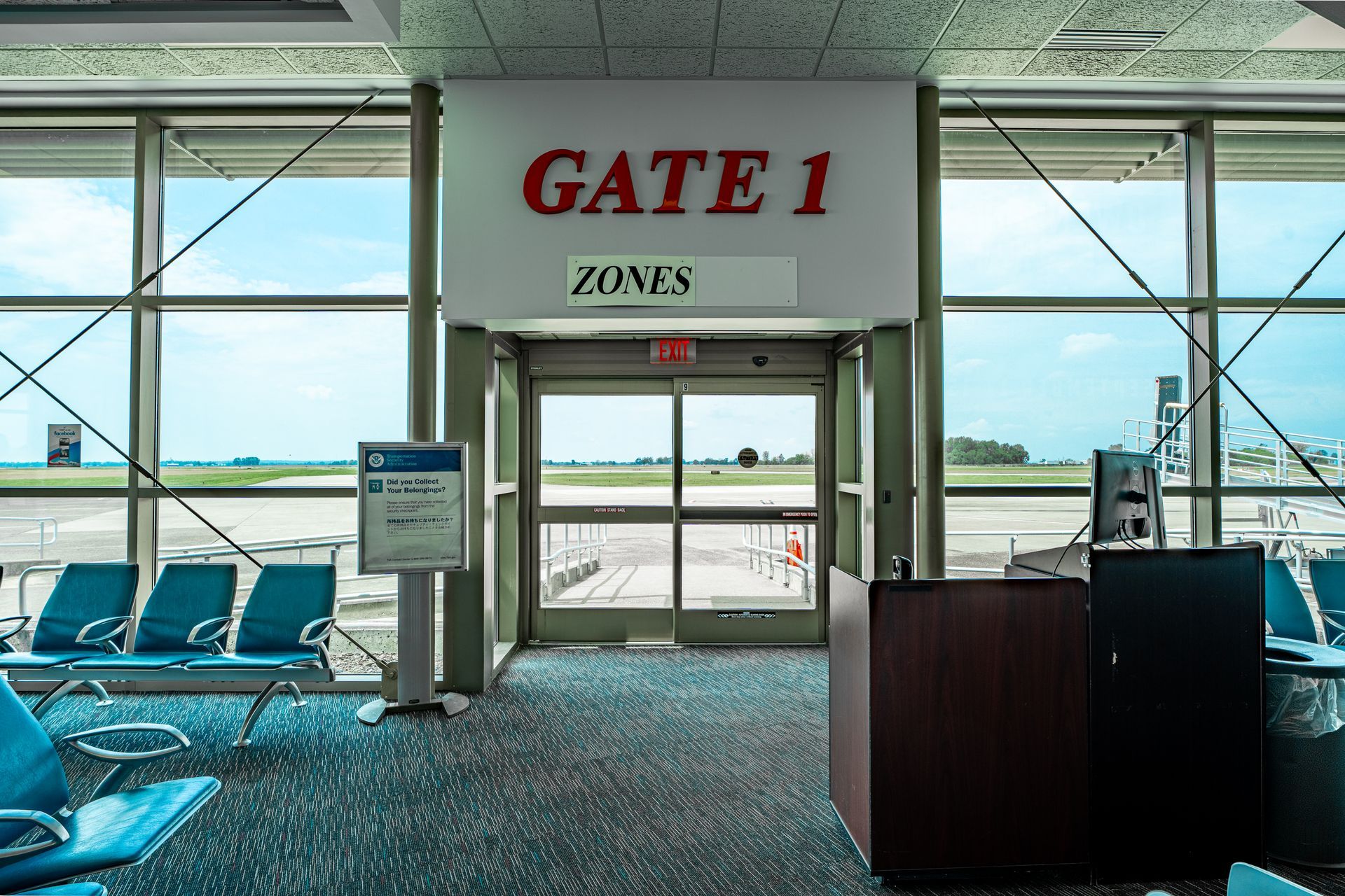 An airport waiting area with a sign that says gate 1 zones