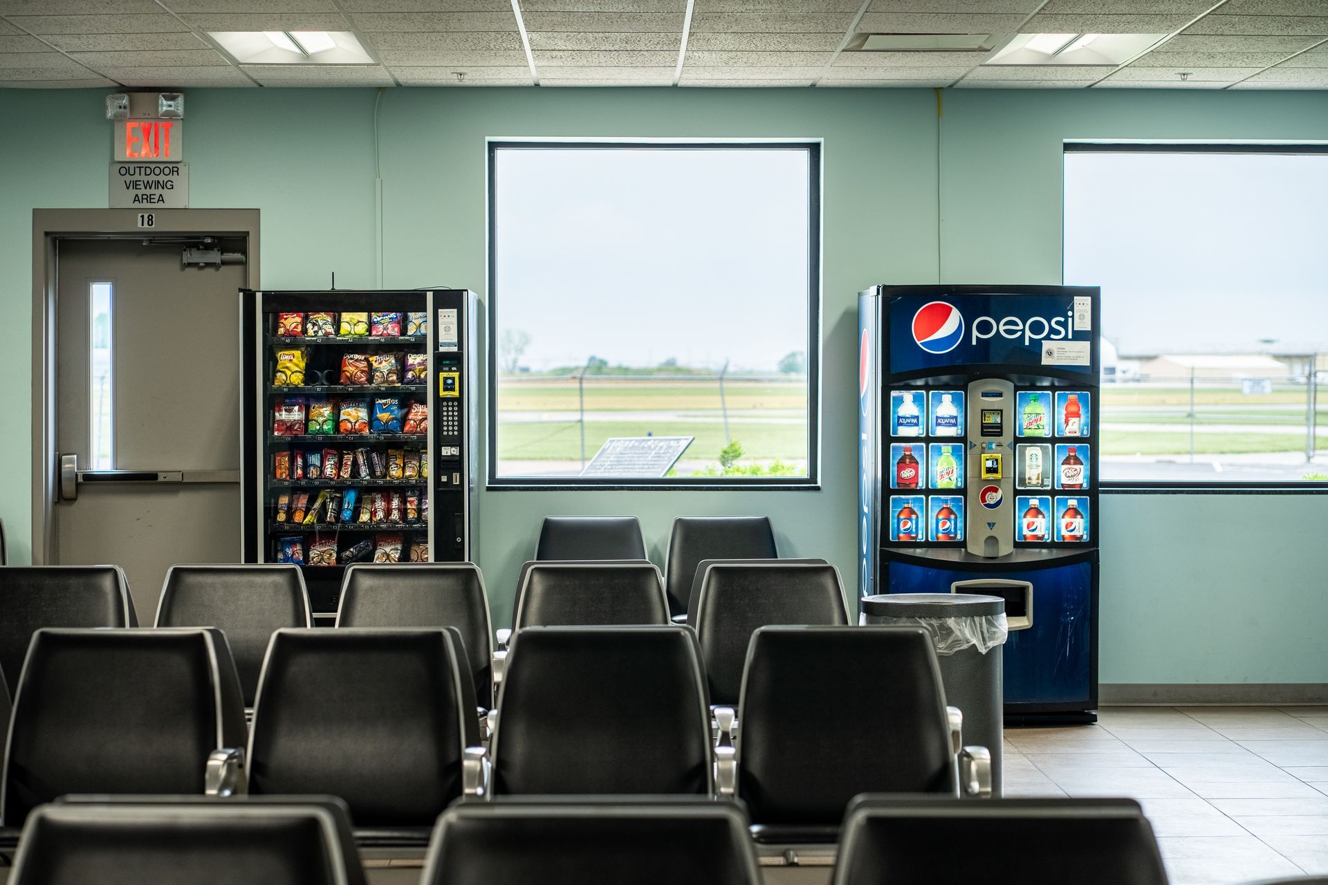 An empty waiting room with a pepsi vending machine