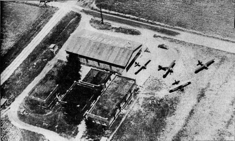 A black and white photo of planes flying over a building