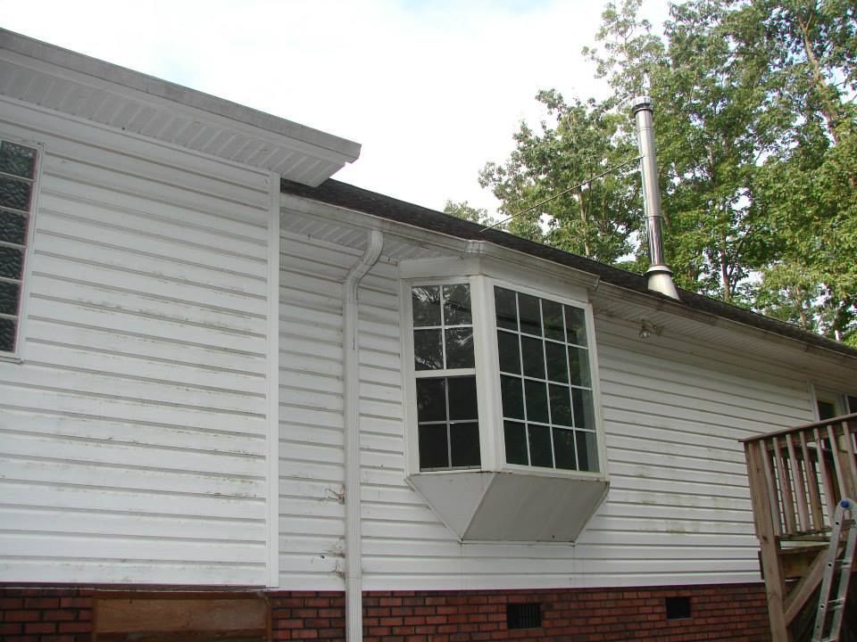 A white house with a bay window and a chimney