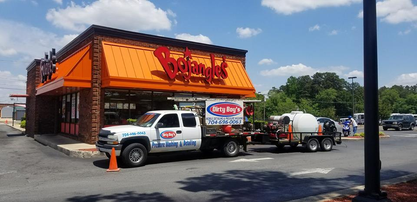 A white truck is parked in front of a restaurant.