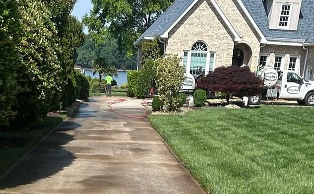 Pressure washing concrete driveway in Mooresville residential home