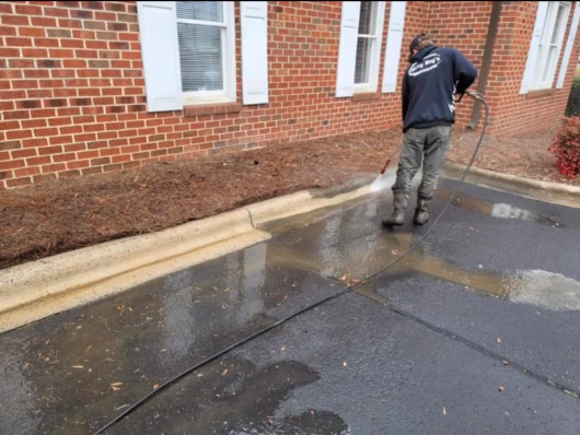 Pressure washing the floor to remove stubborn dirt and grime