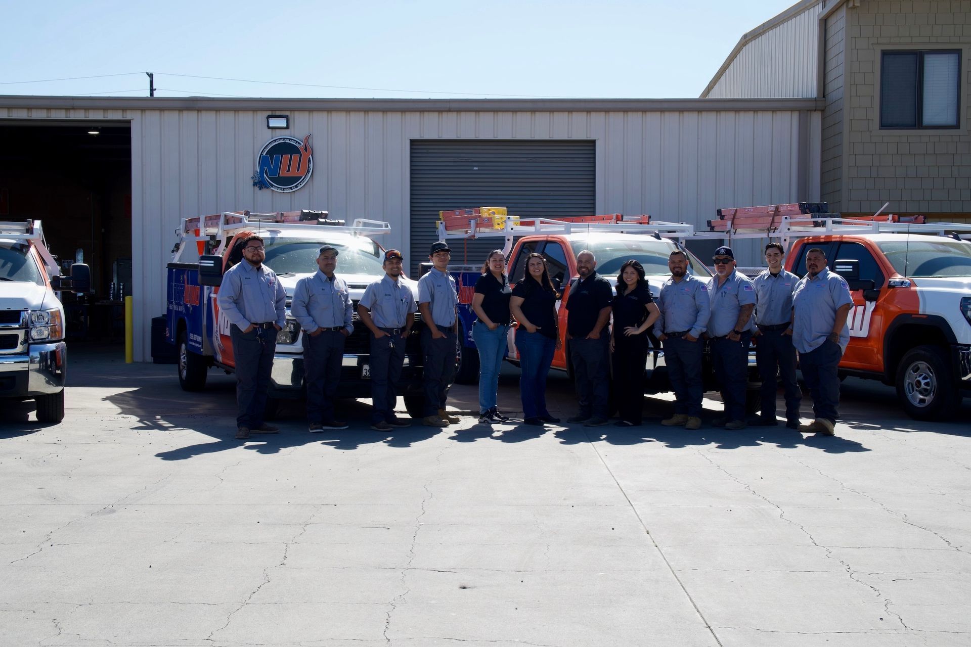 Five people pose smiling in front of a Northwind Heating & Air sign and a service truck.