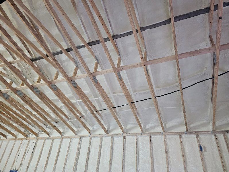 The ceiling of a building is being insulated with spray foam.