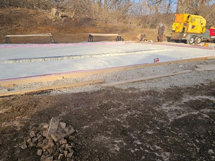 A concrete slab is being poured on a construction site.