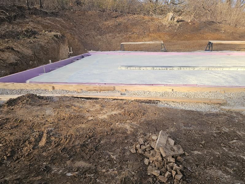 A large concrete slab is sitting in the middle of a dirt field.