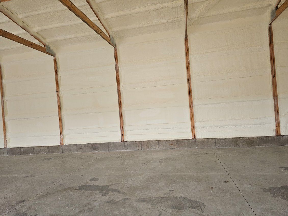 A large empty room with white walls and a concrete floor.
