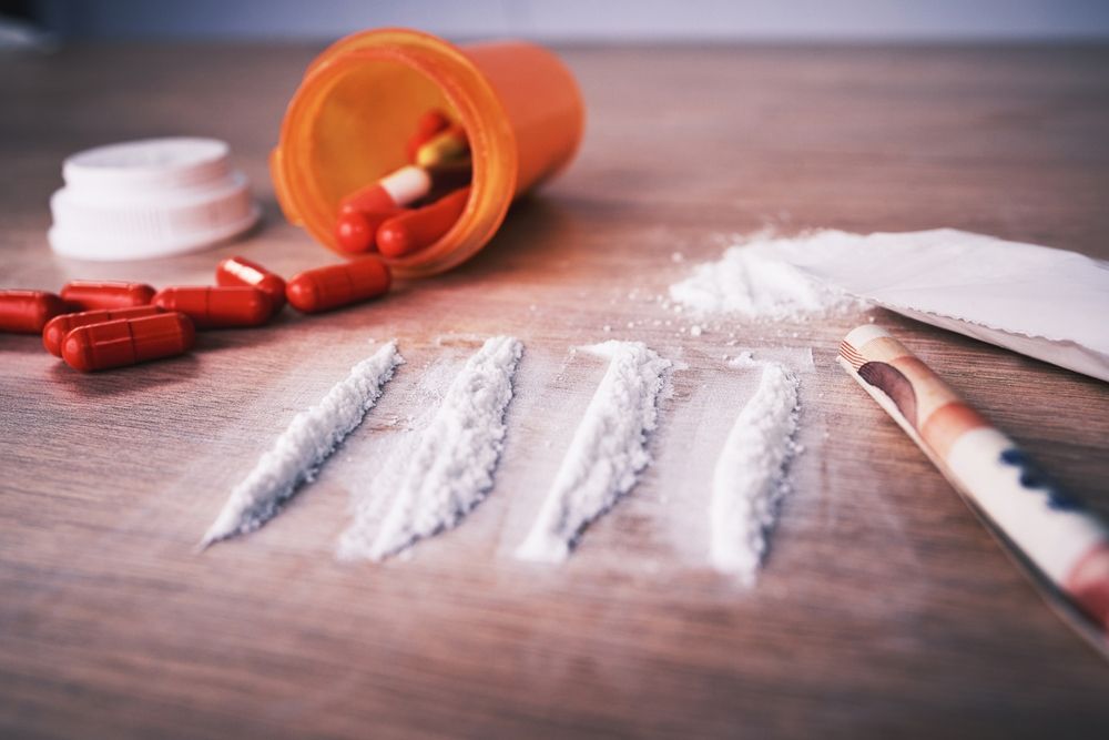 Drugs, addiction and cocaine on table with pills