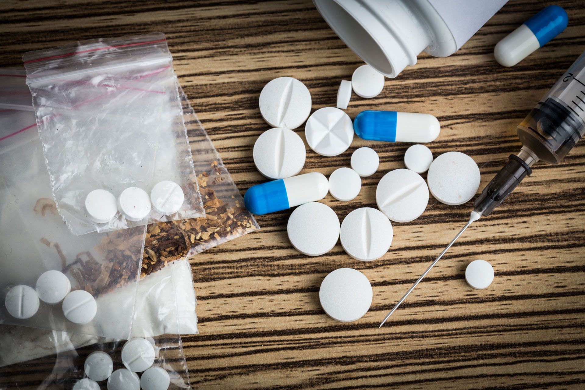 a bottle of pills and a syringe on a table
