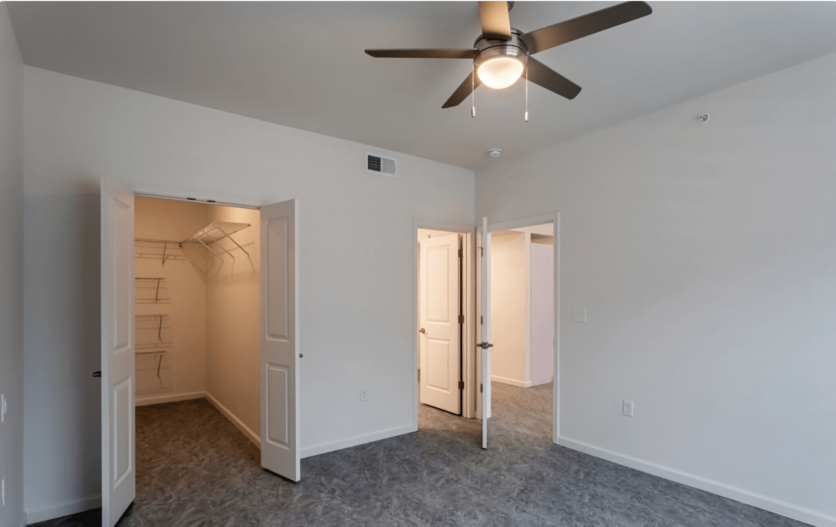 Interior fo bedroom with view into living room and kitchen